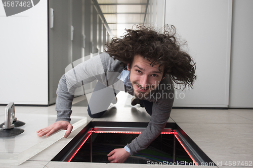 Image of engineer connecting cables in server room