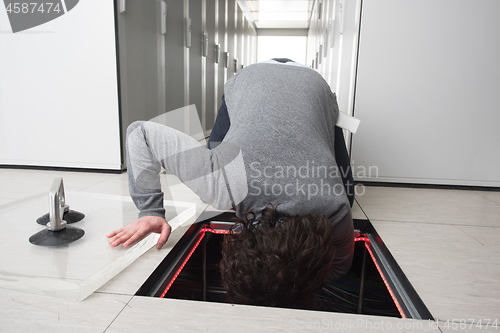 Image of engineer connecting cables in server room