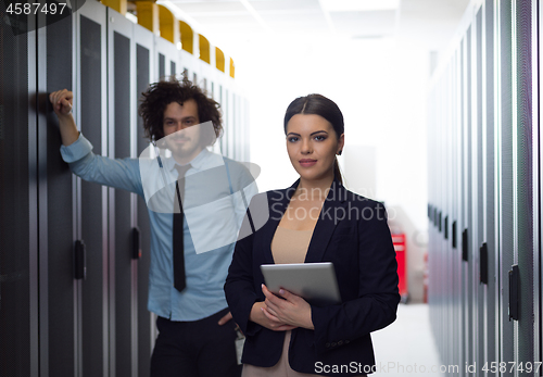 Image of engineer showing working data center server room to female chief