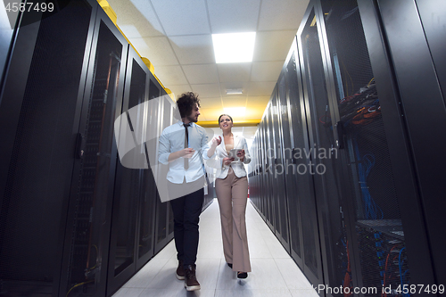 Image of engineer showing working data center server room to female chief