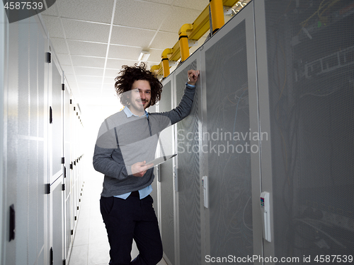 Image of IT engineer working on a tablet computer in server room