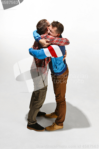 Image of Two friends in casual colorful wear standing and laughing together.