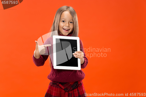 Image of Little funny girl with tablet on studio background