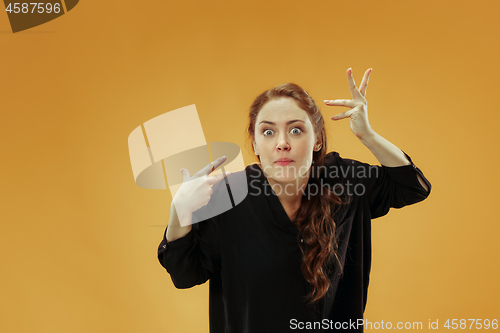Image of Beautiful female half-length portrait isolated on studio backgroud. The young emotional surprised woman