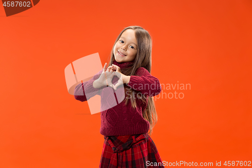 Image of Beautiful smiling teen girl makes the shape of a heart with her hands