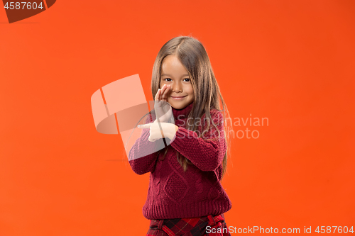 Image of The young teen girl whispering a secret behind her hand