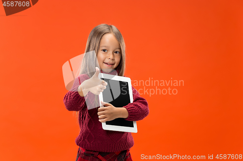 Image of Little funny girl with tablet on studio background