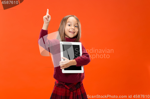 Image of Little funny girl with tablet on studio background