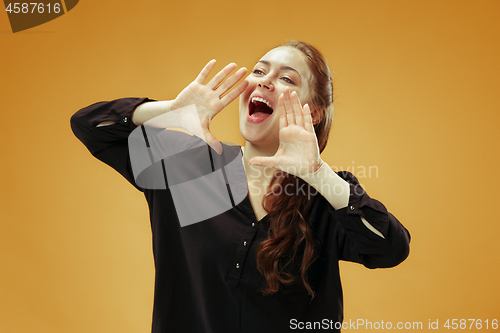 Image of Isolated on orange young casual woman shouting at studio