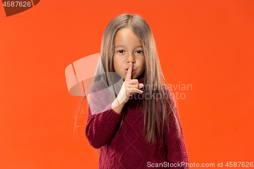 Image of The young teen girl whispering a secret behind her hand