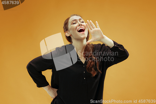 Image of Isolated on orange young casual woman shouting at studio