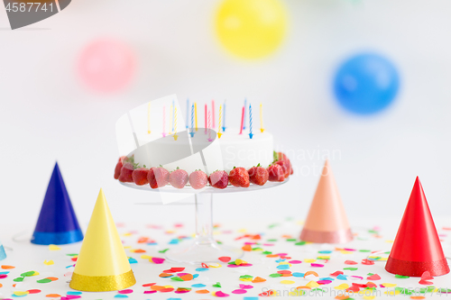 Image of birthday cake with candles and strawberries