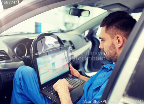 Image of mechanic man with laptop making car diagnostic