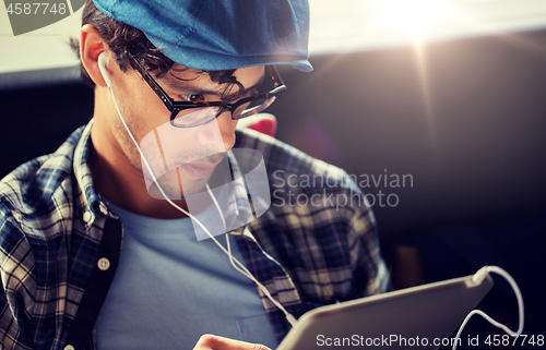 Image of close up of man with tablet pc and earphones