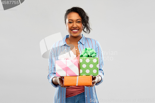 Image of happy african american woman with birthday gifts