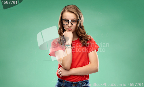 Image of student girl in glasses thinking over green board