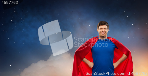 Image of man in red superhero cape over night sky