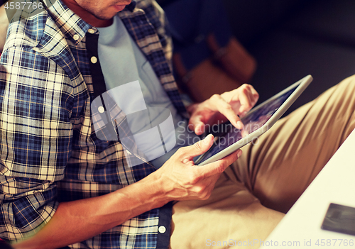 Image of close up of man with tablet pc sitting at cafe