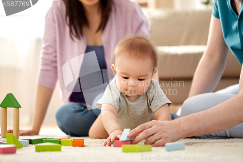 Image of happy family with baby boy playing at home