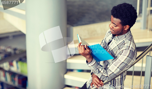 Image of african student boy or man reading book at library