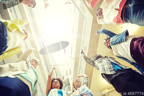 Image of group of international students with hands up