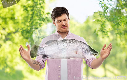 Image of displeased young man showing size of fish