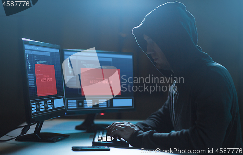 Image of hacker with access denied messages on computer