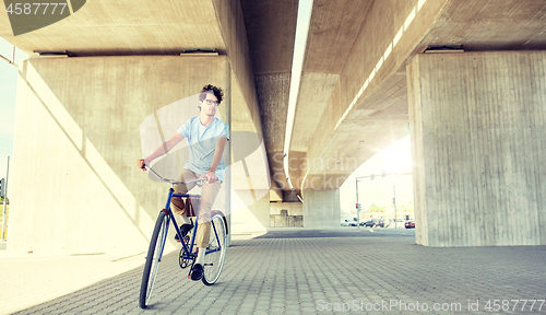 Image of young hipster man riding fixed gear bike