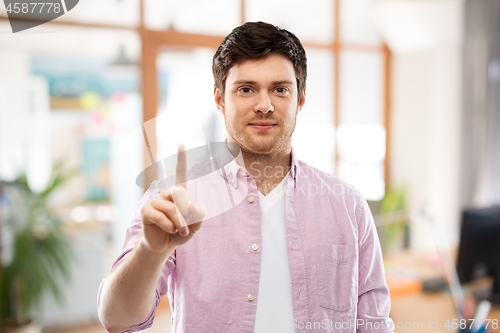 Image of young man showing one finger over office