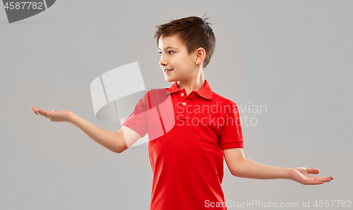 Image of smiling boy holding something on empty hands