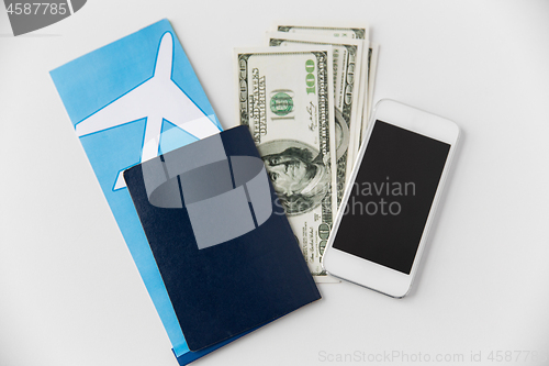 Image of air ticket, money, smartphone and passport