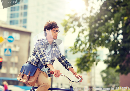 Image of young hipster man with bag riding fixed gear bike