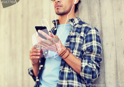 Image of man with earphones and smartphone listening music