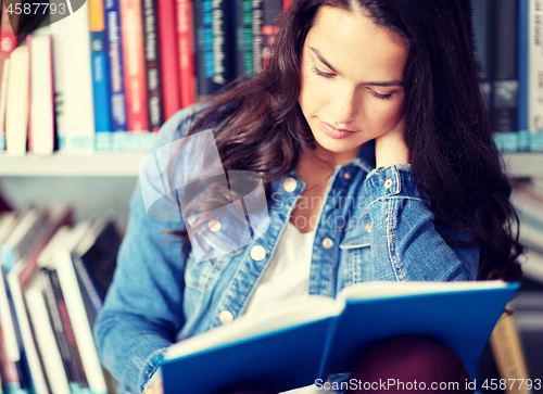 Image of high school student girl reading book at library