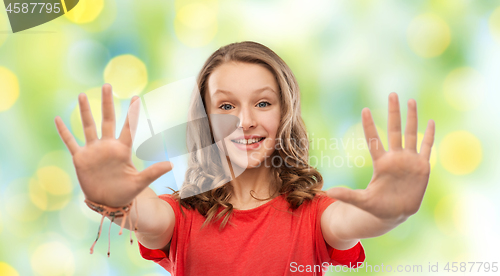 Image of happy teenage girl in red t-shirt giving high five