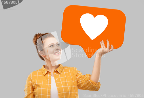 Image of red haired teenage girl holding heart icon