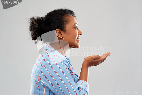 Image of happy african woman holding something on hands