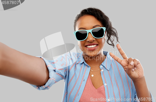 Image of african american woman in sunglasses taking selfie