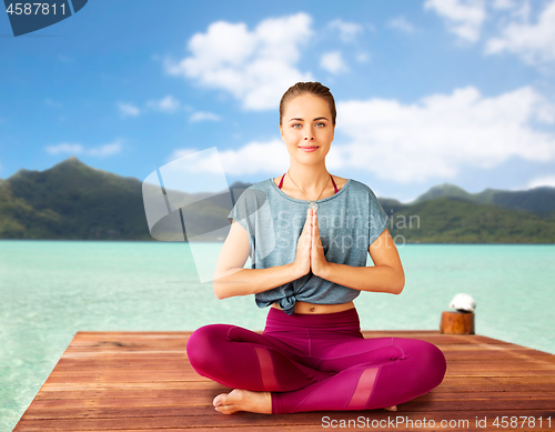 Image of woman doing yoga and meditating in lotus pose