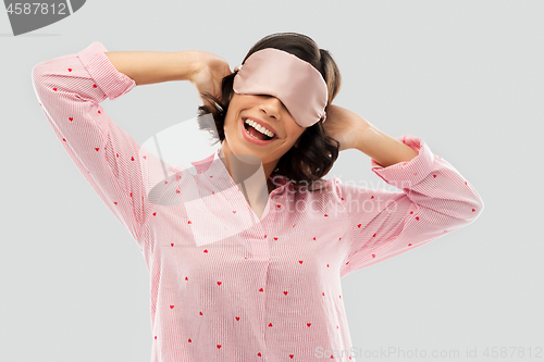 Image of happy young woman in pajama and eye sleeping mask