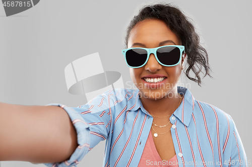 Image of african american woman in sunglasses taking selfie