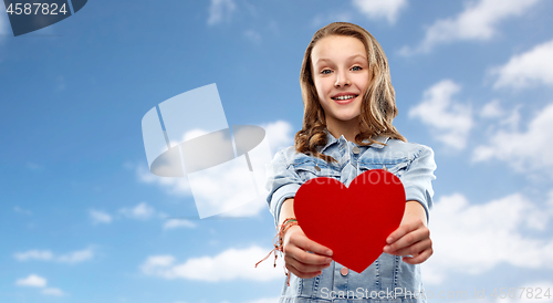 Image of smiling teenage girl with red heart over sky