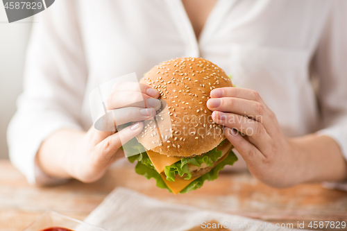 Image of close up of woman holding hamburger