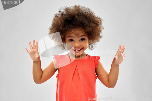 Image of happy little african american girl over grey