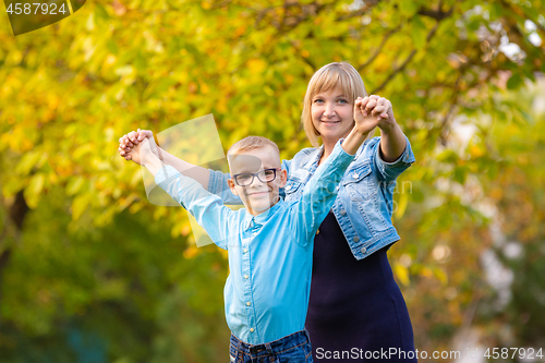 Image of Mom and son seven-year-old son having fun in autumn park