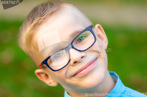 Image of Portrait of a close-up of a cheerful boy with glasses
