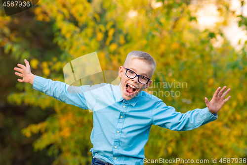 Image of Funny funny boy happily squims and scares in the park