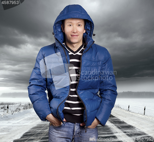 Image of Asian man stand on snow road in winter