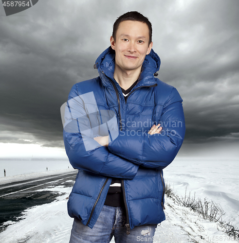 Image of Asian man stand on snow road in winter