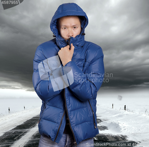 Image of Asian man stand on snow road in winter